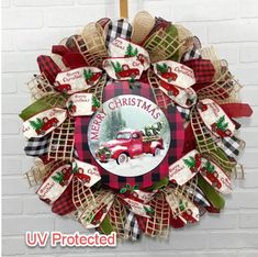 a christmas wreath with an old red truck on the front and plaid ribbon around it