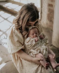 a woman holding a baby in her arms