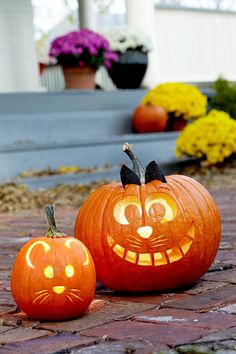 two pumpkins with faces carved into them