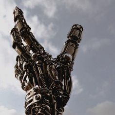 a very large metal animal sculpture in front of a cloudy sky