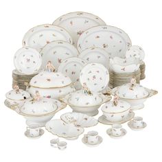 a collection of porcelain dishes, cups and saucers with figurines on them