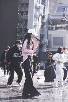 a woman standing on top of a street holding a microphone