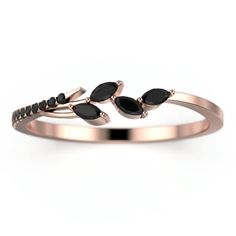 a rose gold ring with black stones and leaves on the front, set in 18k pink gold