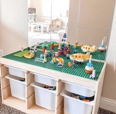 a toy table with legos on it in front of a mirror and some bins