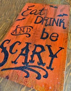 a wooden sign that says eat drink and be scary