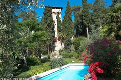 an outdoor swimming pool surrounded by trees and flowers