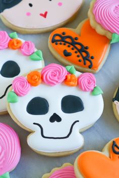 decorated sugar cookies in the shape of children's skulls and skeletons on a marble surface