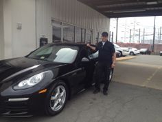 a man standing next to a black sports car