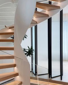 a white spiral staircase with wooden handrails