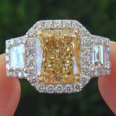 a fancy yellow diamond ring with three baguets