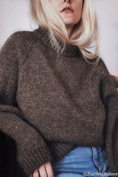 a woman with blonde hair wearing a brown sweater