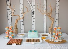 the dessert table is decorated with birch trees