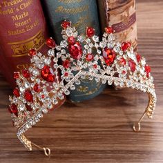 a red and white tiara sitting on top of a wooden table next to books