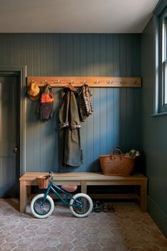 a bike is parked in front of a bench and coat rack with coats hanging on it