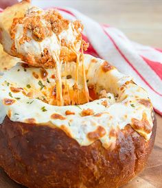 a cheesy bread dish being lifted from a bagel