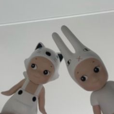 two dolls are posed in front of a white background