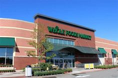 a whole foods market is shown on the side of a building with green awnings