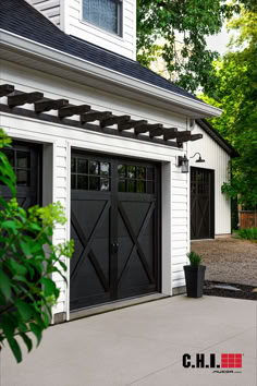 black overlay garage doors with windows on white modern farmhouse home Farmhouse Garage Doors, Garage Doors Black, Beautiful Beach Houses, Black Farmhouse, Dream Beach Houses, Overhead Door, Home Addition, House Paint Exterior