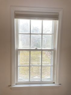 an empty window in the corner of a room with white walls and trim on it