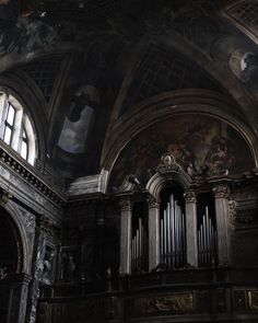 the interior of an old church with many paintings on the walls and pipe organ in the foreground