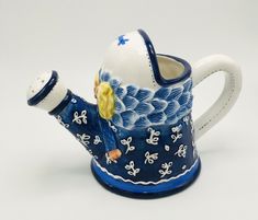 a blue and white teapot with a blonde haired girl on it's side