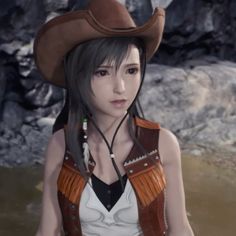 a woman wearing a cowboy hat and leather vest standing in water with rocks behind her