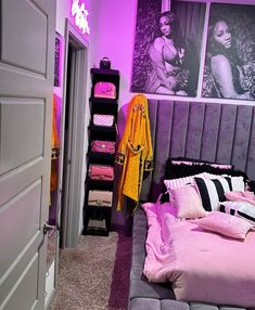 a bedroom decorated in pink and purple with pictures on the wall