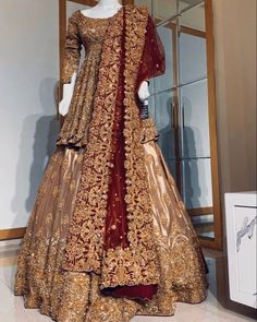 a mannequin dressed in an elaborate gold and red gown