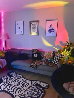 a living room filled with lots of furniture and colorful lights on the wall above it