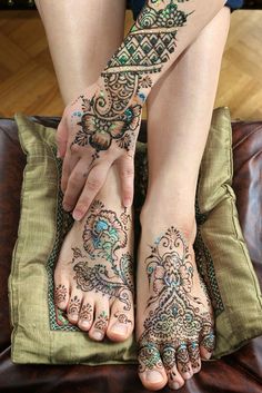 a woman's feet with henna tattoos on them