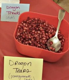 a red bowl filled with dragon teas next to a sign that says dragon tears