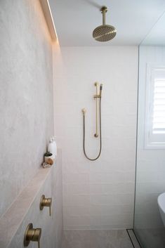 a bathroom with a walk in shower next to a white bathtub and toilet paper