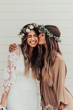 two beautiful women standing next to each other with flowers in their hair and wearing flower crowns