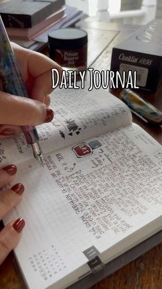 a person writing on a notebook with the words daily journal written in it and two hands holding a pen