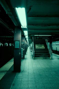 an empty subway station with stairs leading up to it