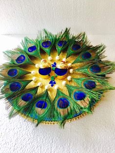 peacock feathers are arranged in the shape of a flower on a white surface with blue accents