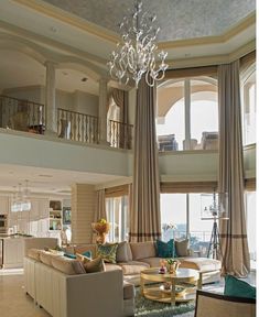 a living room filled with furniture and a chandelier in the middle of it