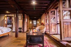 a room with wooden walls and flooring that has a red rug on the floor