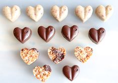 heart shaped chocolates are arranged in the shape of hearts on a blue surface with white background