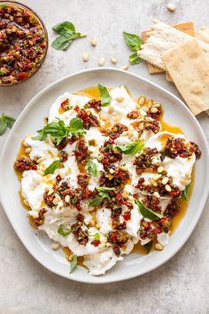 a white plate topped with food next to crackers