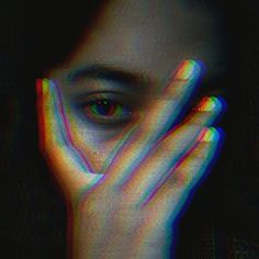 a woman's face with her hands on her face and the image is multicolored