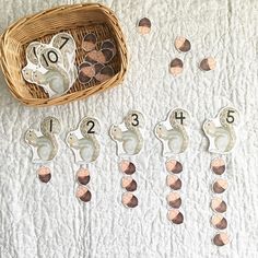 a basket filled with lots of coins sitting on top of a white bed covered in numbers