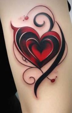 a heart tattoo on the thigh with swirls and curls around it's sides