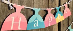 some paper dresses hanging on a clothes line with the words happy birthday written in large letters