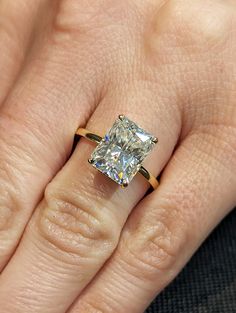 a woman's hand with a ring on it and a diamond in the middle