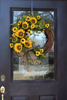 a wreath with sunflowers is hanging on the front door's glass window