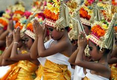 young children dressed in colorful costumes and headdresses are applauding each other