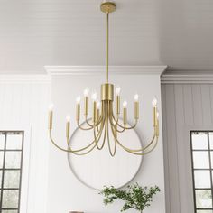 a chandelier hanging from the ceiling in a room with white walls and windows