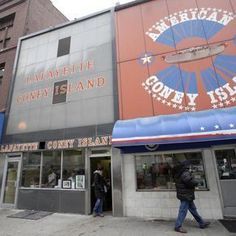 people walking in front of an american cony island restaurant