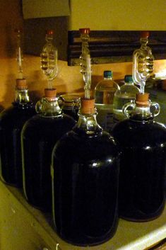 four black jugs sitting on top of a stove